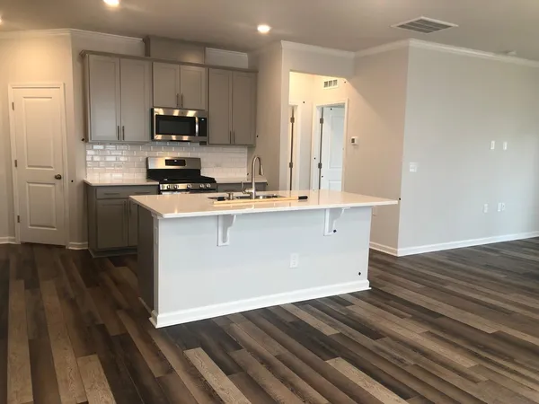 a kitchen with wooden floors and white cabinets