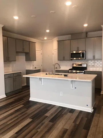 a kitchen with kitchen island wooden cabinets and stainless steel appliances