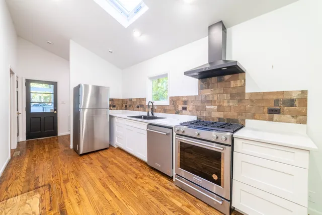 a kitchen with granite countertop a sink stainless steel appliances and cabinets