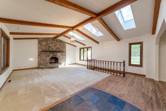 an empty room with fireplace and windows