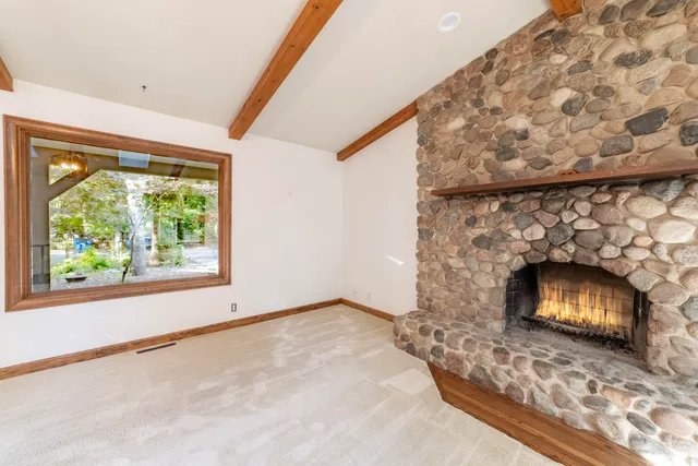 a view of empty room with fireplace and window