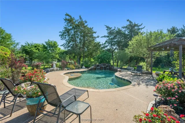 a swimming pool with outdoor seating and yard