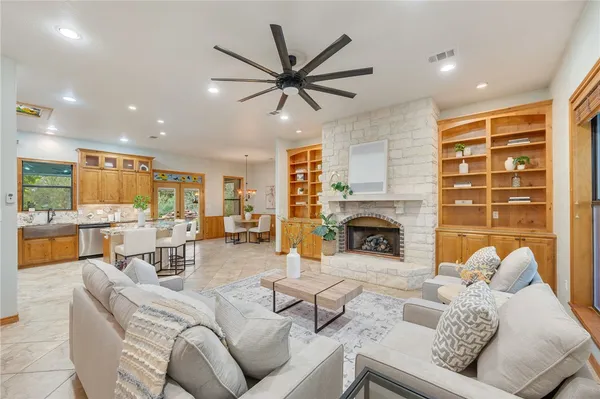 a living room with furniture a fireplace and a dining table with kitchen view
