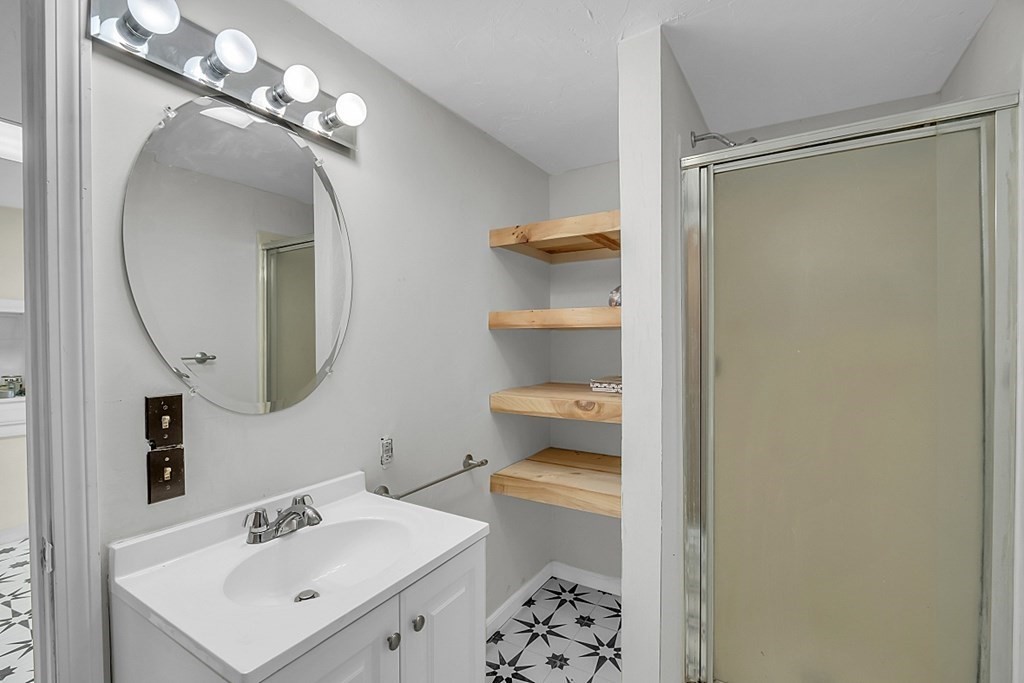 320 Bolton Road Lancaster, MA 01523 - Photo 6 of 28 a bathroom with a sink a mirror a vanity and a shower