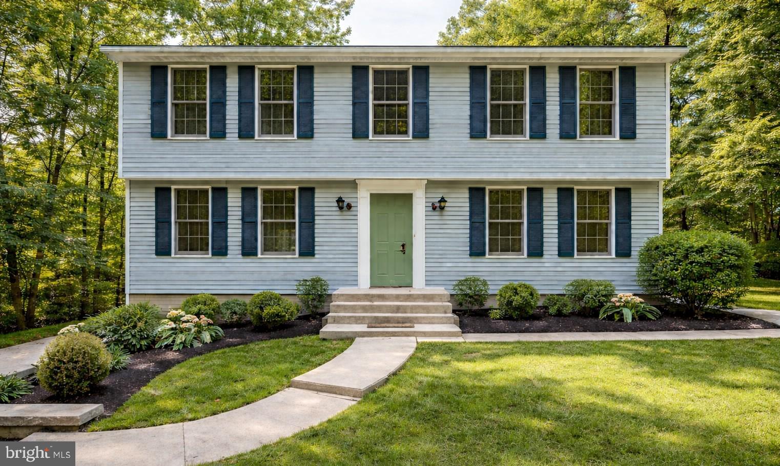 a front view of a house with yard and green space