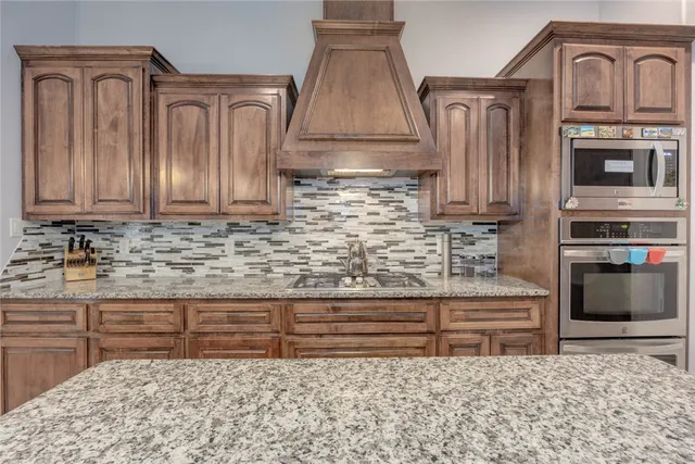 a kitchen with granite countertop a sink and a stove top oven
