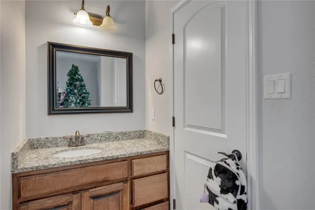 a bathroom with a granite countertop sink and a mirror