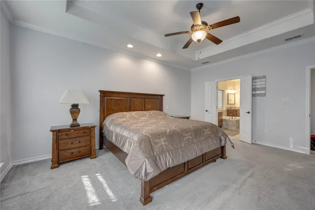 a spacious bedroom with a bed and a ceiling fan
