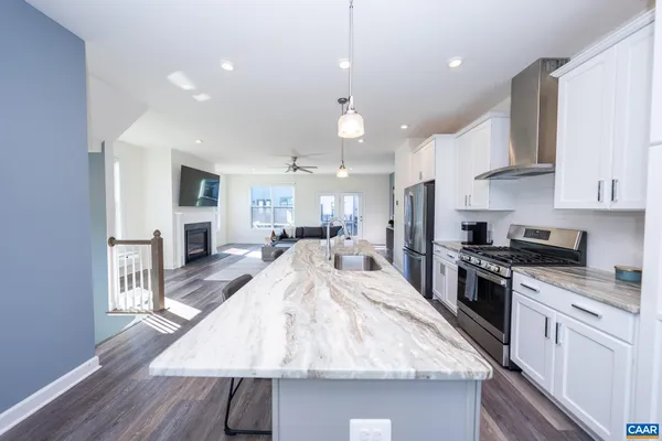 a large kitchen with kitchen island a stove a sink a refrigerator and cabinets