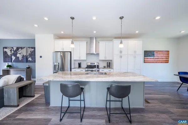 a kitchen with kitchen island a dining table chairs cabinets and stainless steel appliances