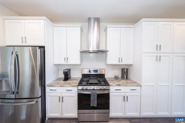 a kitchen with appliances a refrigerator and cabinets