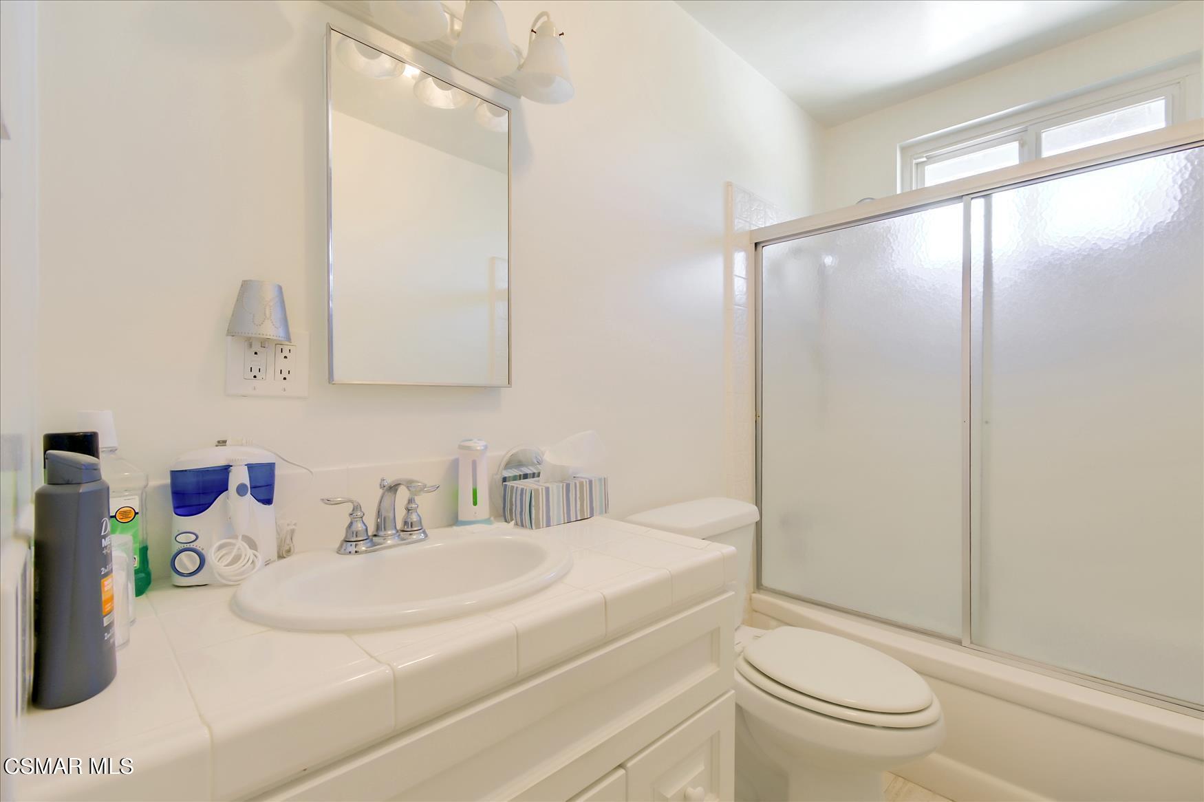 4245 Adam Road Simi Valley, CA 93063 - Photo 14 of 20 a bathroom with a granite countertop sink a toilet and a mirror