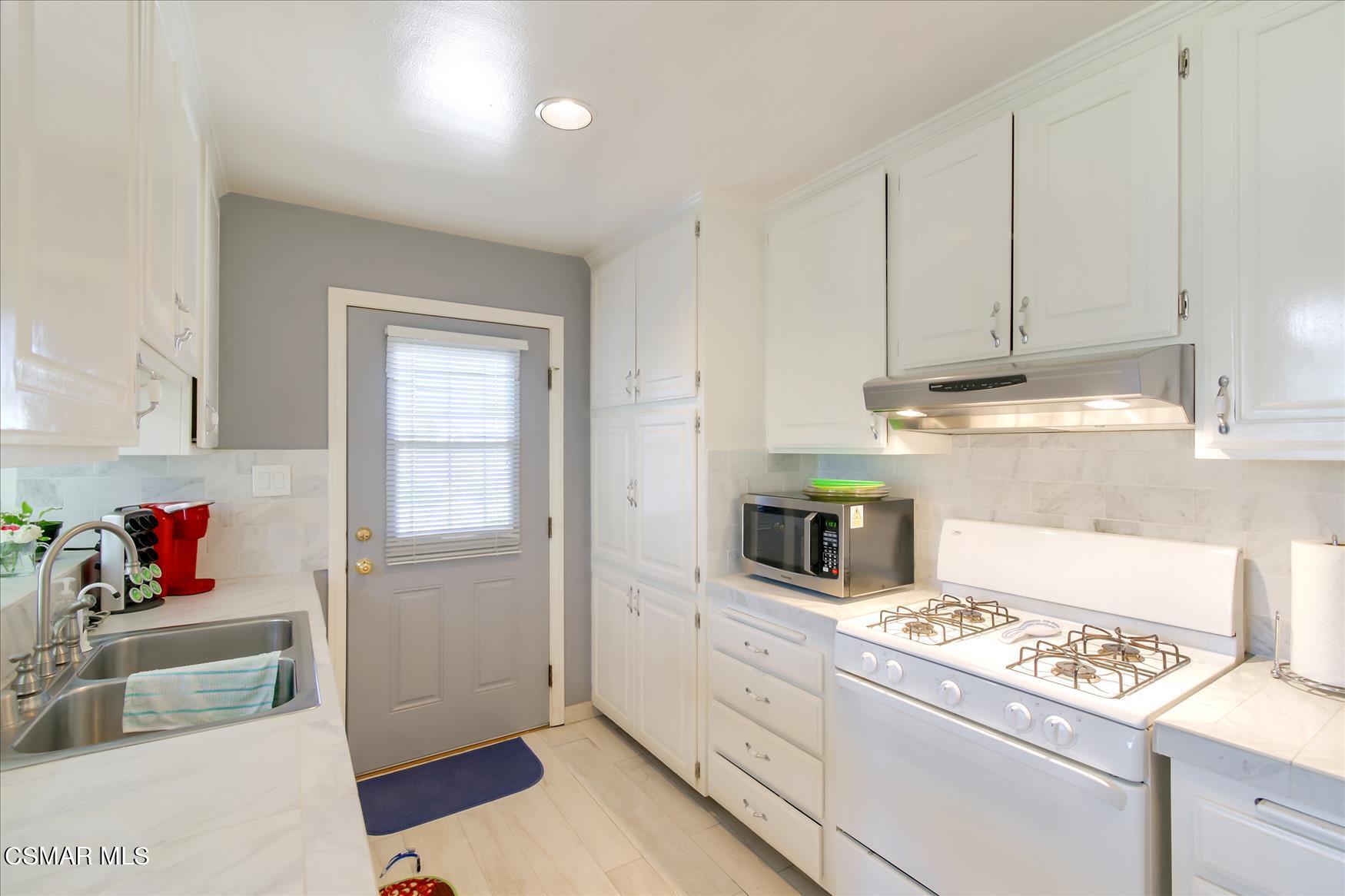 4245 Adam Road Simi Valley, CA 93063 - Photo 4 of 20 a kitchen with a stove and white cabinets