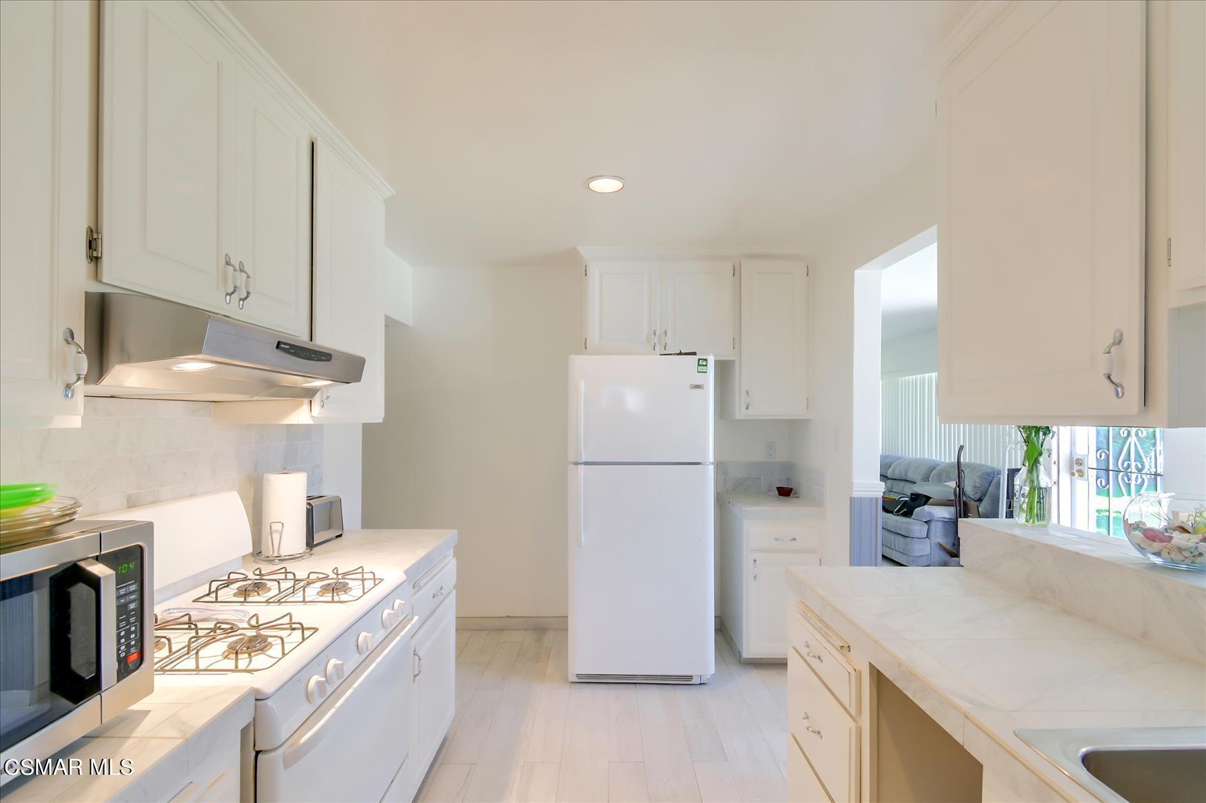4245 Adam Road Simi Valley, CA 93063 - Photo 5 of 20 a kitchen with a stove a refrigerator and a sink
