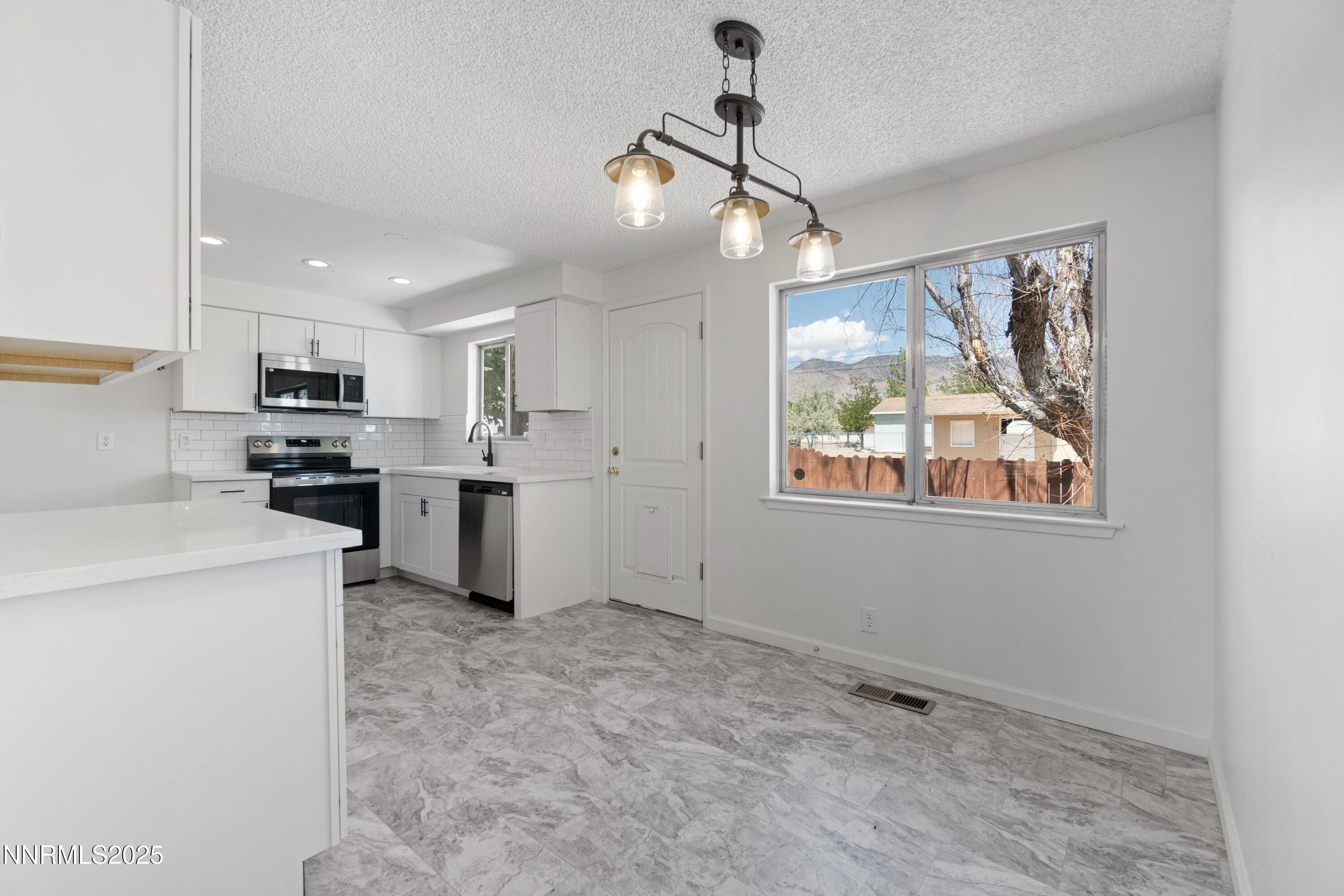 129 Ring Road Dayton, NV 89403 - Photo 11 of 27 a kitchen with stainless steel appliances kitchen island granite countertop a refrigerator and a stove top oven