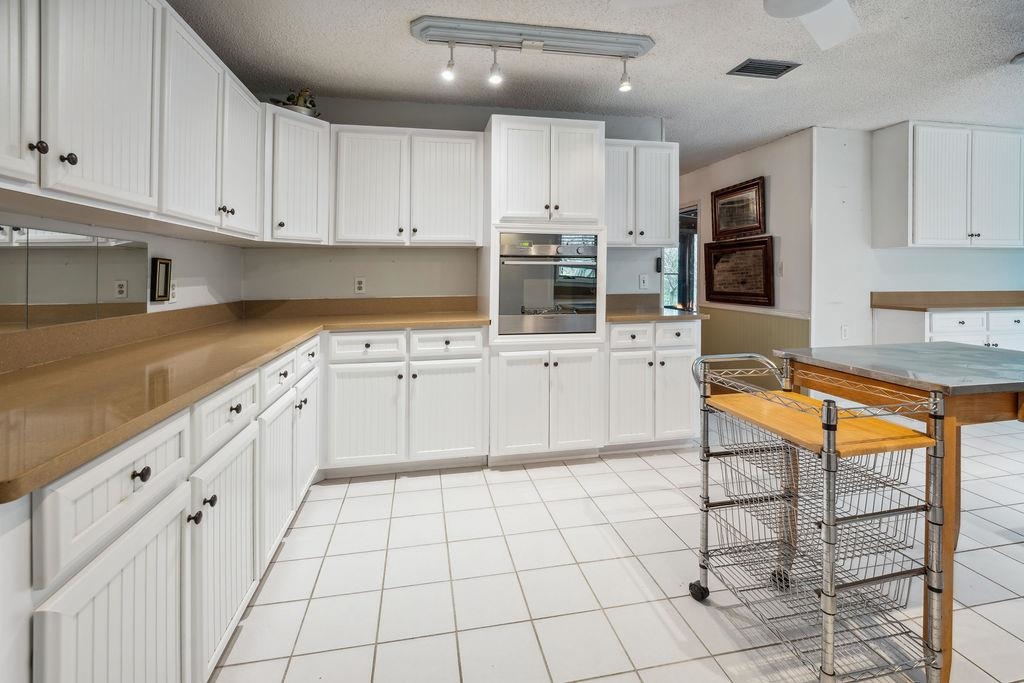 708 Prince Road St. Augustine, FL 32086 - Photo 16 of 41 a kitchen with stainless steel appliances granite countertop a stove a sink and white cabinets