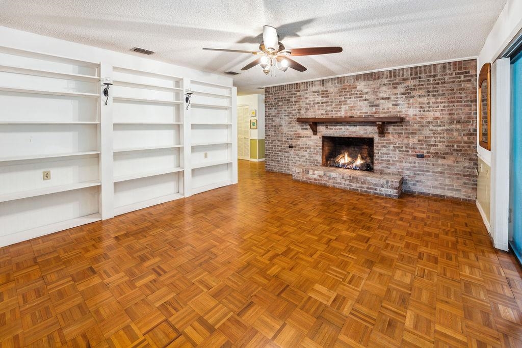 708 Prince Road St. Augustine, FL 32086 - Photo 10 of 41 a living room with a fireplace and a ceiling fan