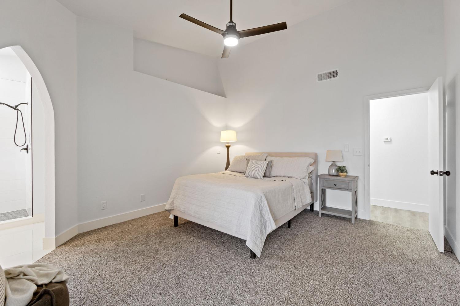 2481 Gibson Avenue Clovis, CA 93611 - Photo 13 of 24 a spacious bedroom with a bed and a chandelier