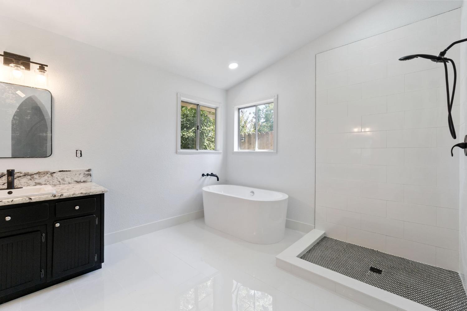 2481 Gibson Avenue Clovis, CA 93611 - Photo 15 of 24 a spacious bathroom with a bathtub sink mirror and toilet
