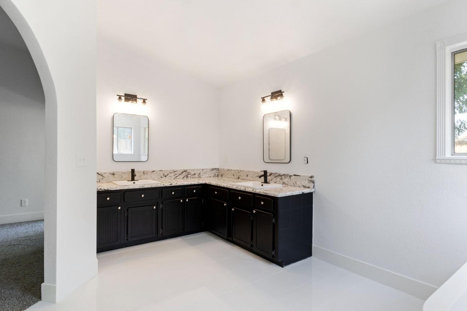 2481 Gibson Avenue Clovis, CA 93611 - Photo 17 of 24 a spacious bathroom with a double vanity sink and a mirror