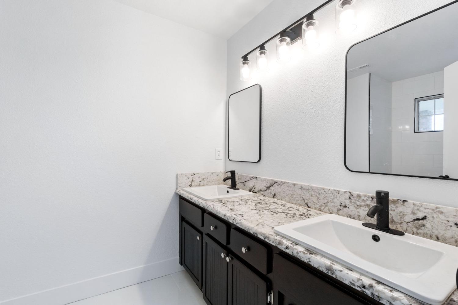 2481 Gibson Avenue Clovis, CA 93611 - Photo 21 of 24 a bathroom with a double vanity sink and a mirror