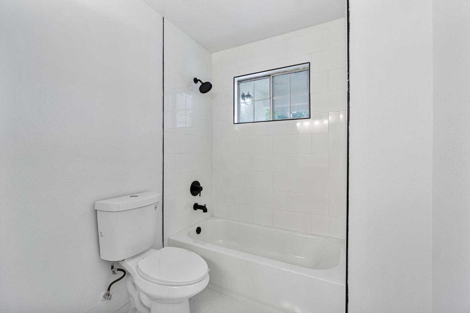 2481 Gibson Avenue Clovis, CA 93611 - Photo 22 of 24 a white toilet sitting next to a bath tub