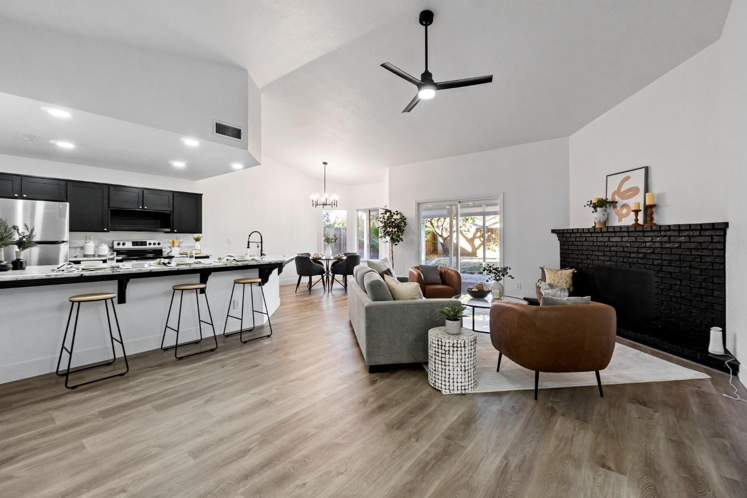 2481 Gibson Avenue Clovis, CA 93611 - Photo 5 of 24 a living room with fireplace furniture and a wooden floor