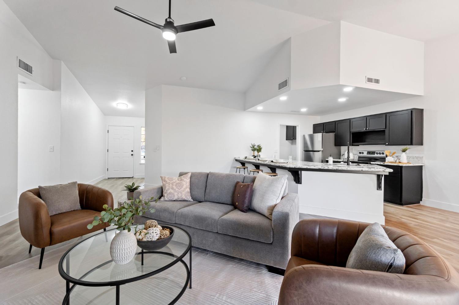 2481 Gibson Avenue Clovis, CA 93611 - Photo 7 of 24 a living room with furniture kitchen view and a chandelier