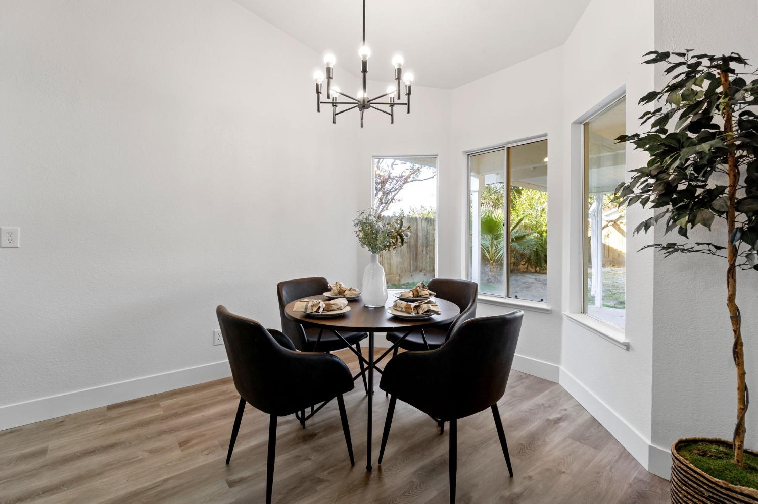 2481 Gibson Avenue Clovis, CA 93611 - Photo 10 of 24 a dining room with furniture a chandelier and wooden floor