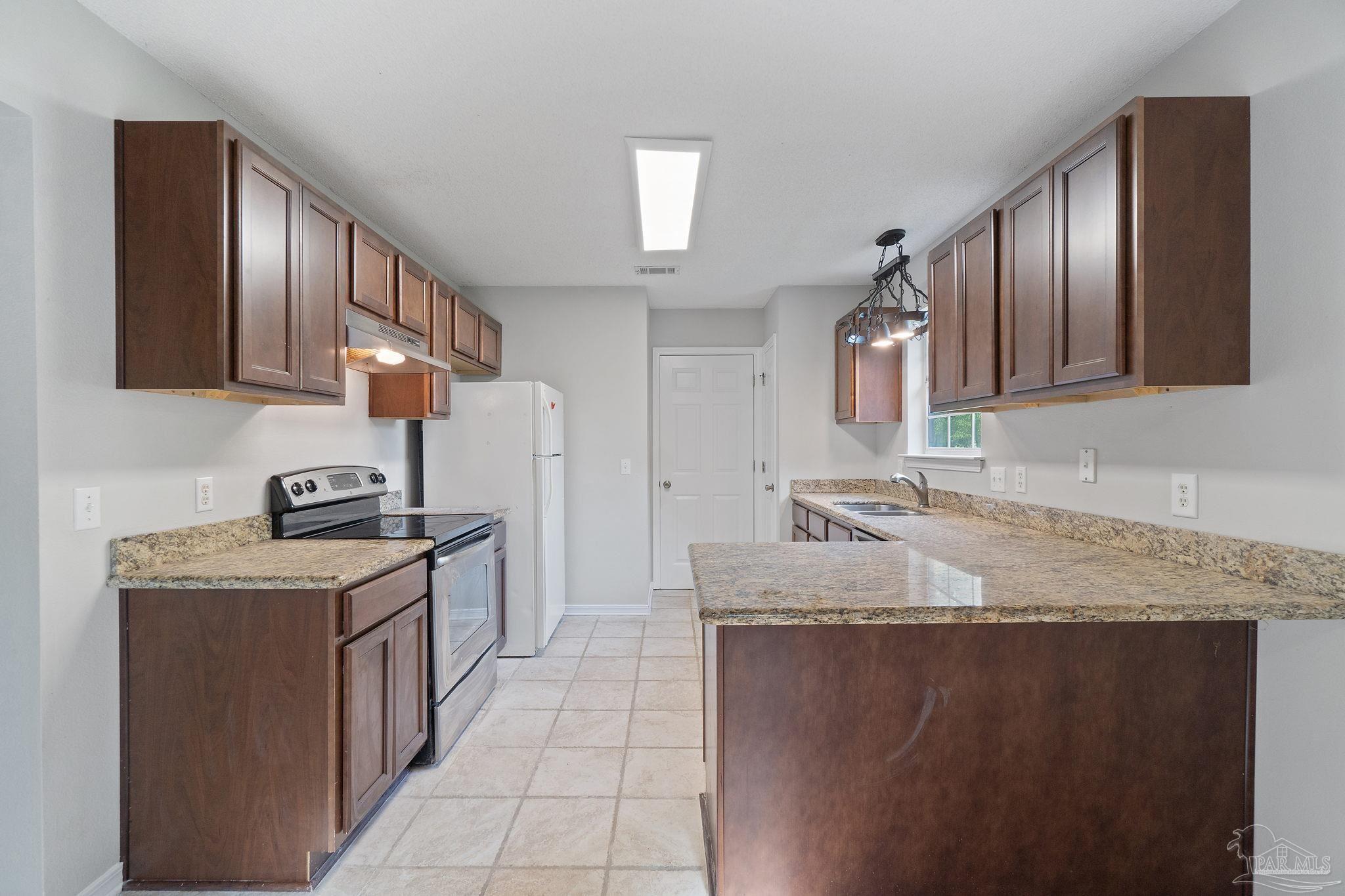 6216 Billoree Road Milton, FL 32571 - Photo 28 of 50 a kitchen with stainless steel appliances granite countertop a sink stove and refrigerator