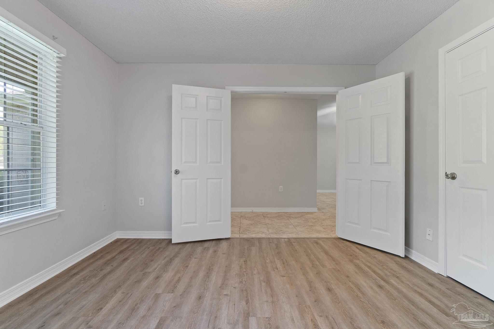 6216 Billoree Road Milton, FL 32571 - Photo 7 of 50 an empty room with wooden floor and windows