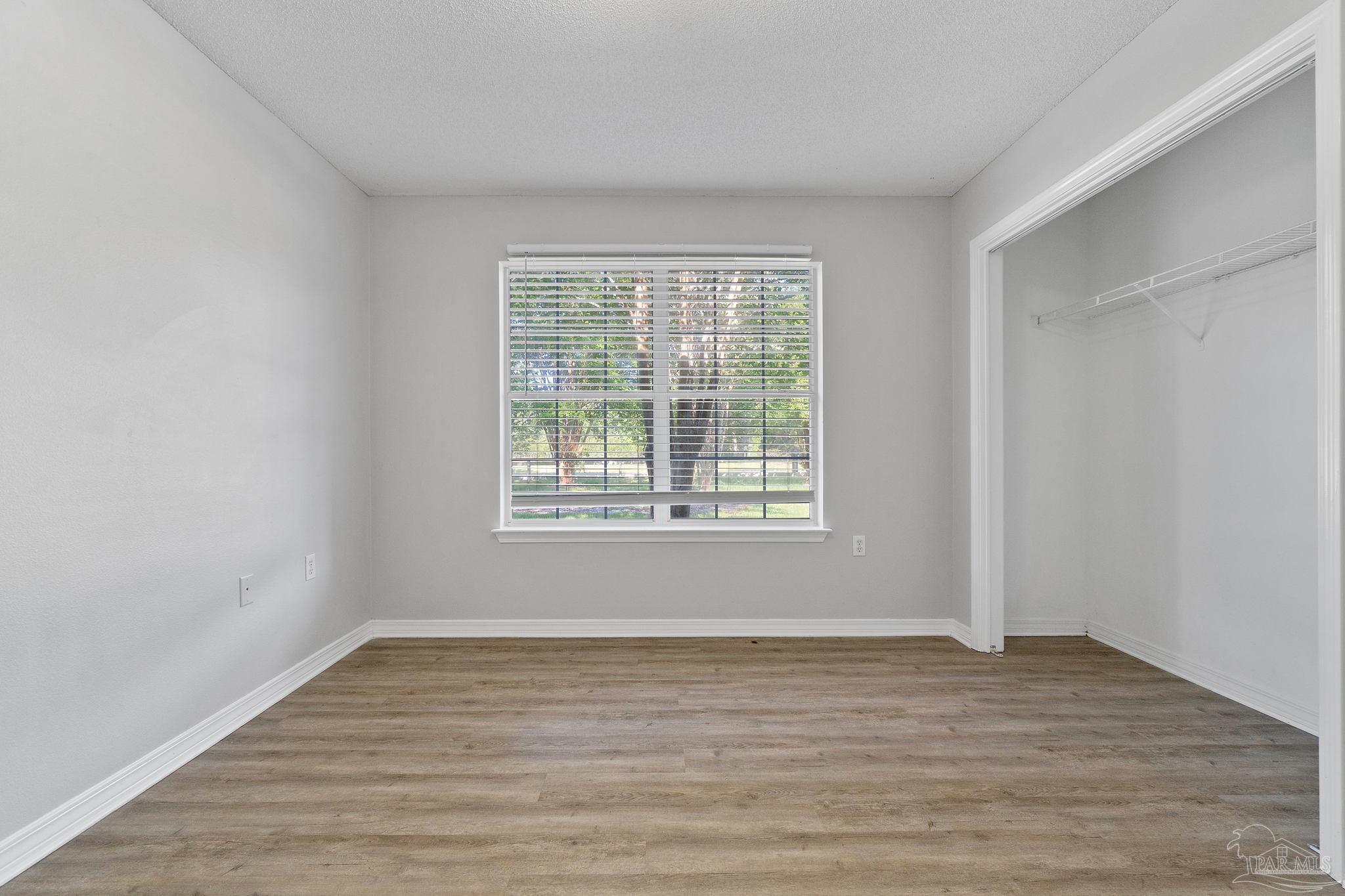 6216 Billoree Road Milton, FL 32571 - Photo 8 of 50 a view of an empty room with wooden floor and a window
