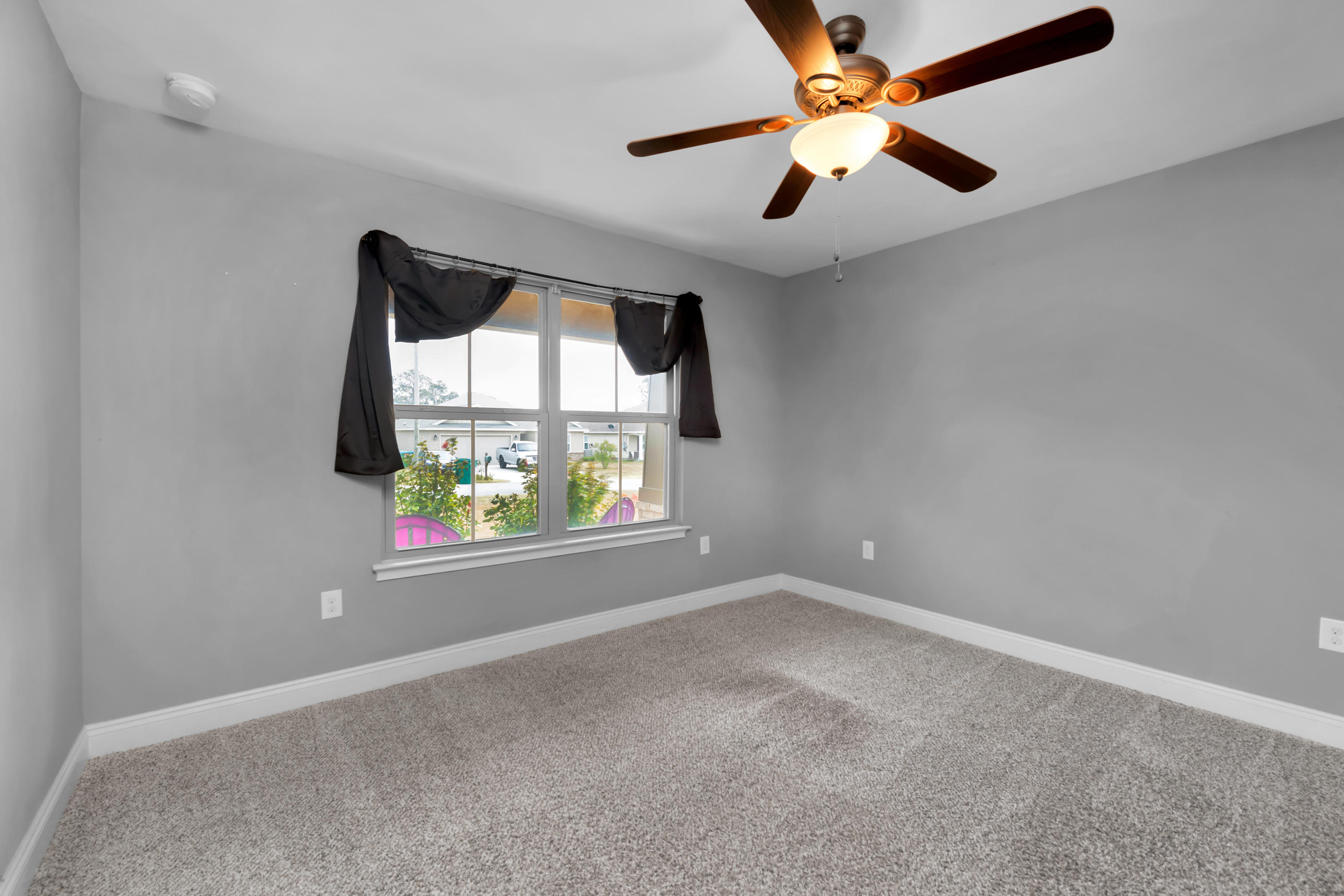 2047 Alhambra Street Navarre, FL 32566 - Photo 16 of 24 an empty room with a window and a fan
