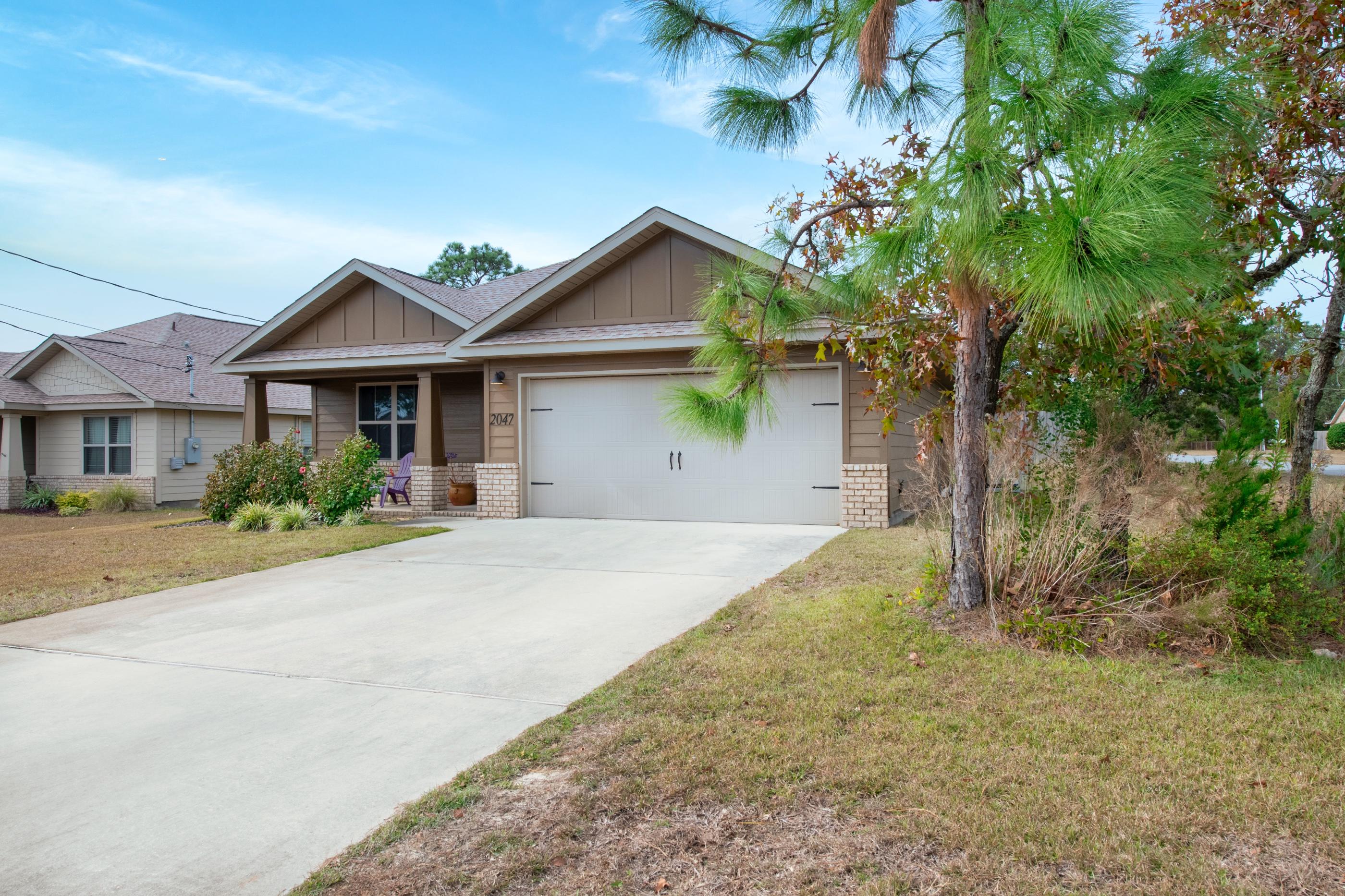 2047 Alhambra Street Navarre, FL 32566 - Photo 2 of 24 a front view of house with yard and green space