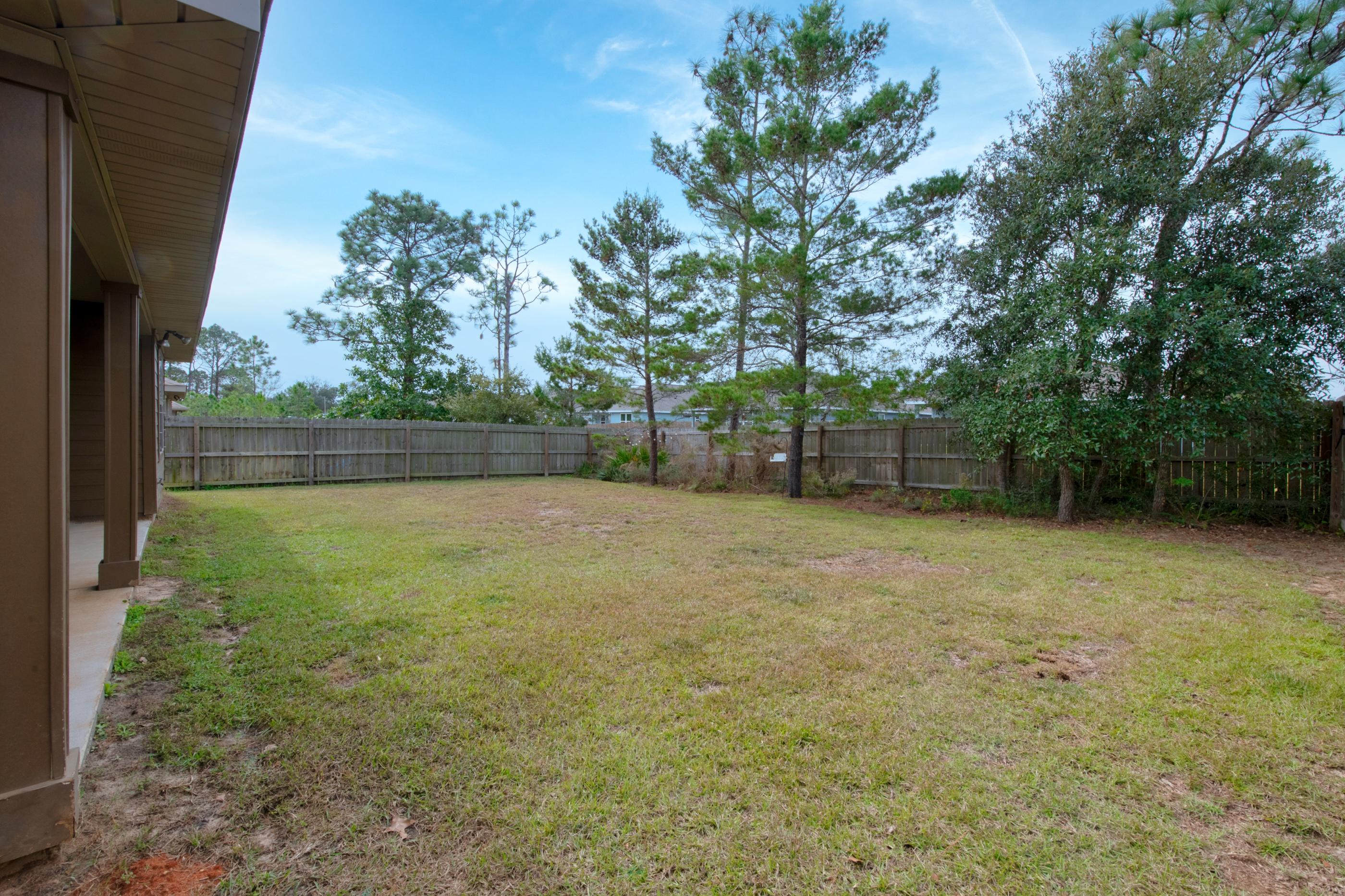2047 Alhambra Street Navarre, FL 32566 - Photo 21 of 24 a view of a yard with a tree