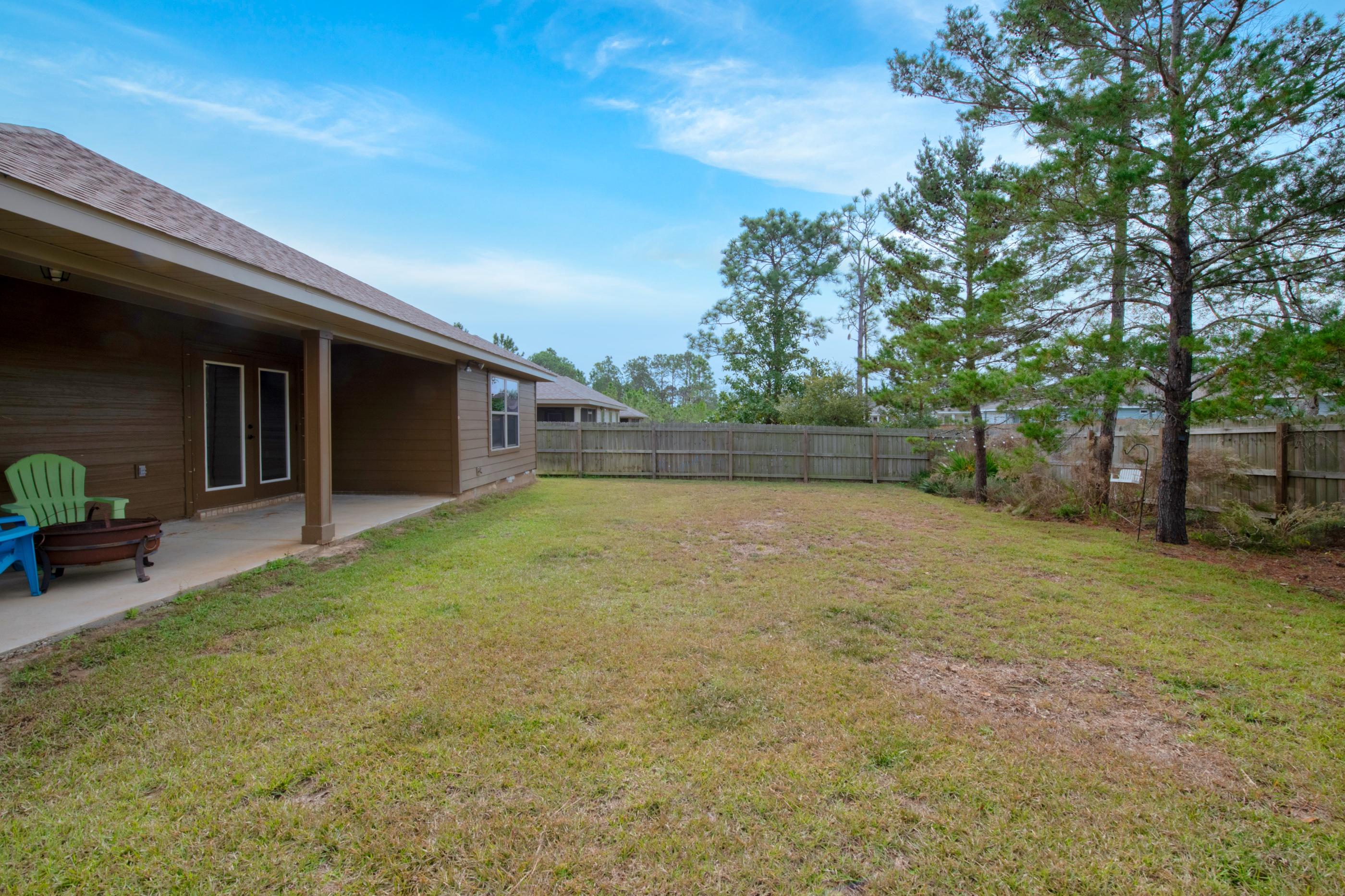 2047 Alhambra Street Navarre, FL 32566 - Photo 22 of 24 a backyard of a house with lots of green space