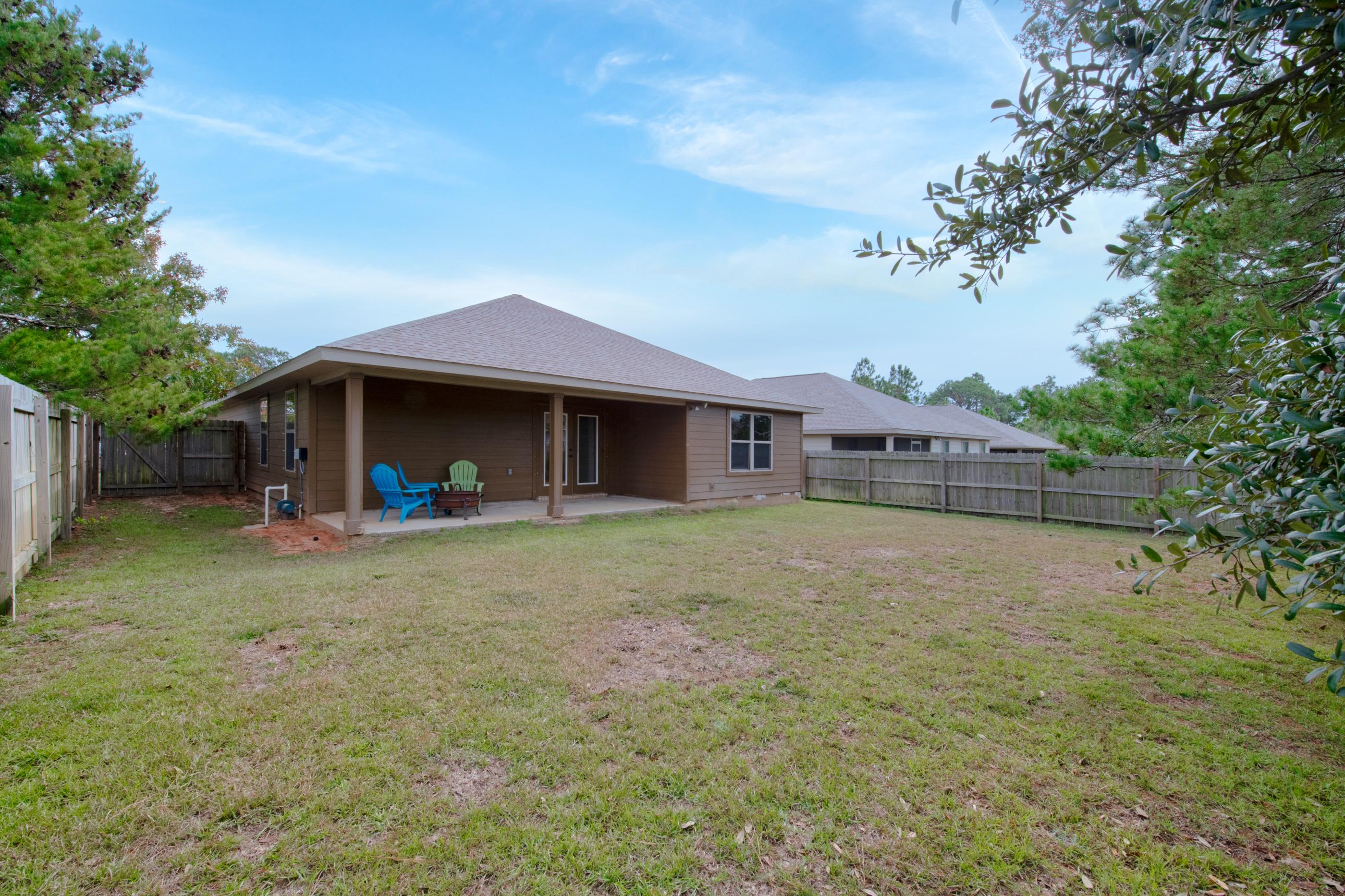 2047 Alhambra Street Navarre, FL 32566 - Photo 23 of 24 a front view of a house with a yard