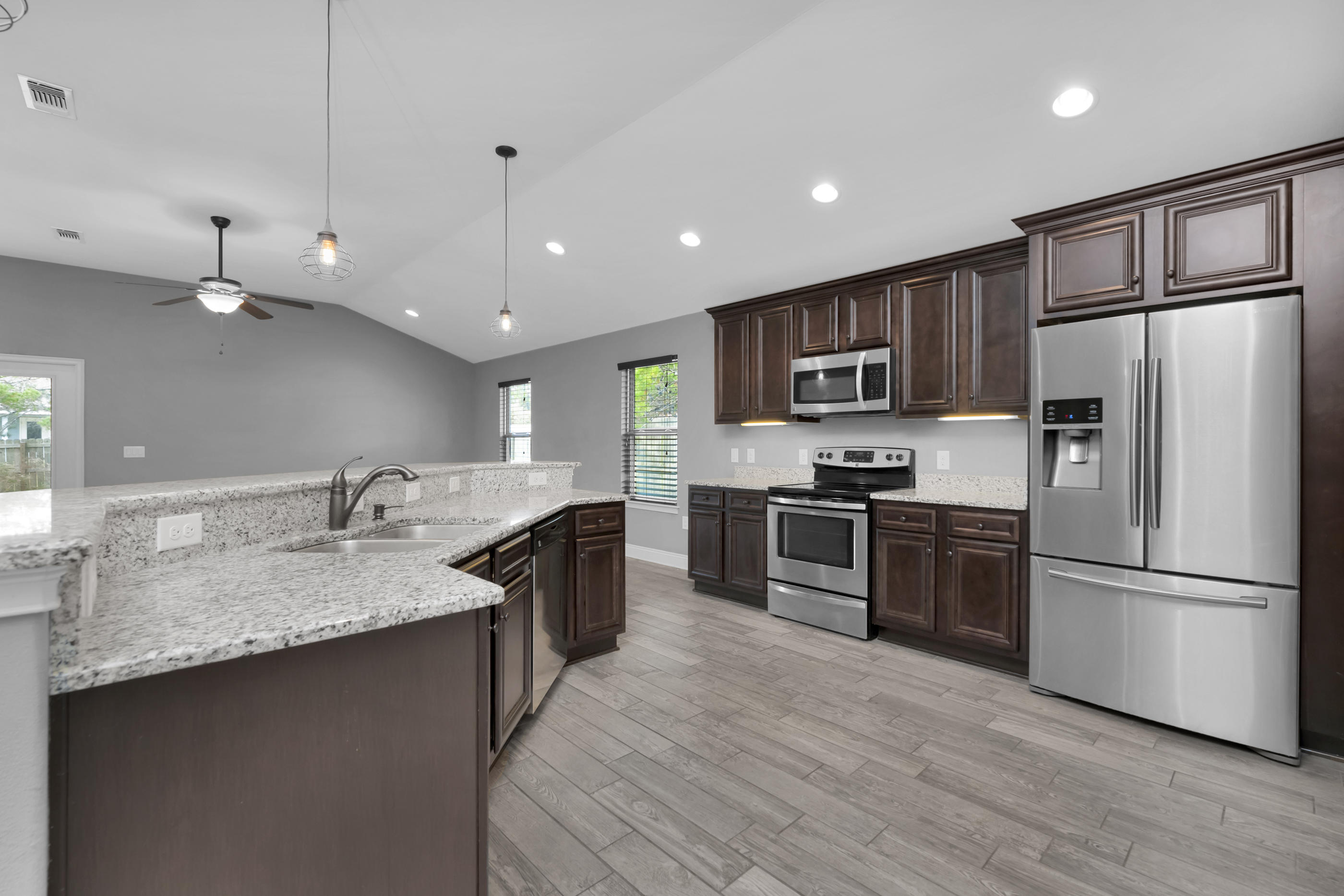 2047 Alhambra Street Navarre, FL 32566 - Photo 5 of 24 a kitchen with kitchen island granite countertop stainless steel appliances and wooden cabinets
