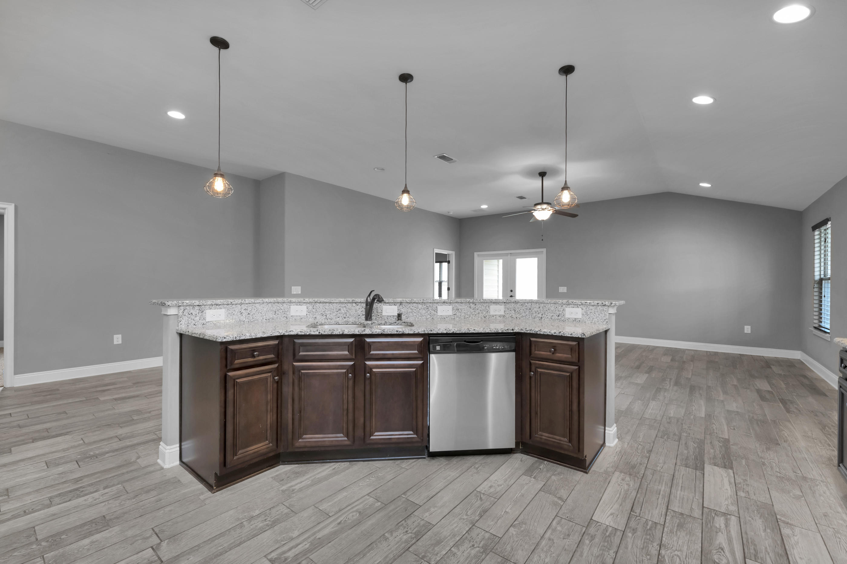 2047 Alhambra Street Navarre, FL 32566 - Photo 6 of 24 a kitchen with kitchen island granite countertop a sink cabinets and wooden floor