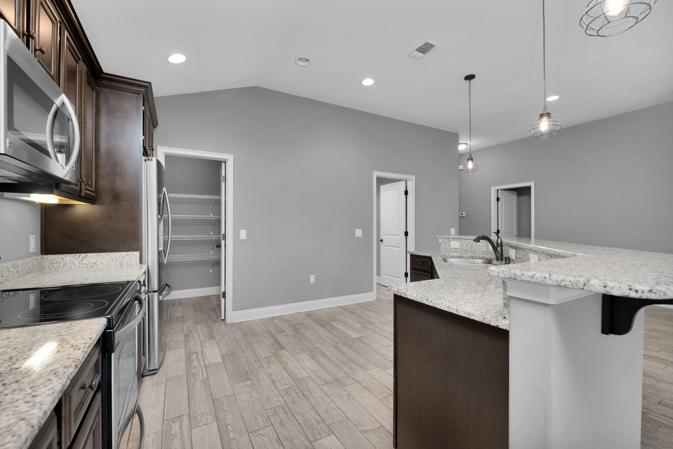 2047 Alhambra Street Navarre, FL 32566 - Photo 7 of 24 a kitchen with stainless steel appliances granite countertop a sink and a stove top oven