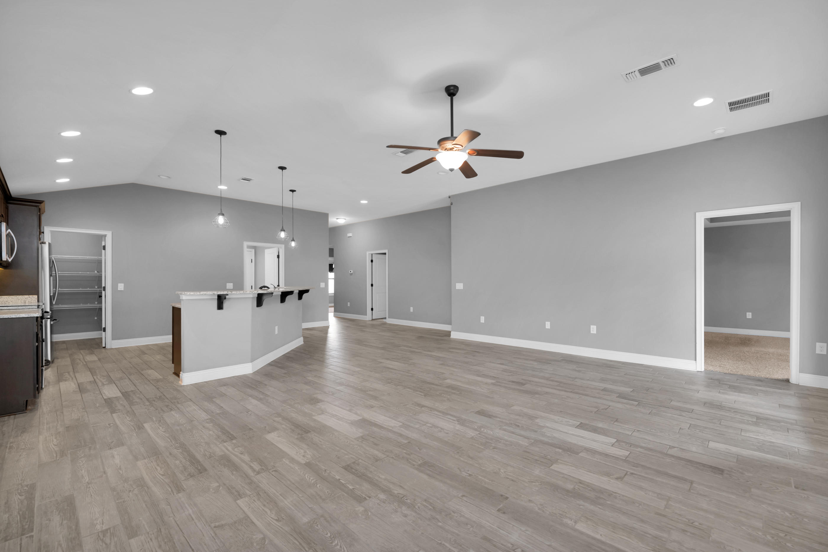 2047 Alhambra Street Navarre, FL 32566 - Photo 9 of 24 a view of an empty room and kitchen with microwave