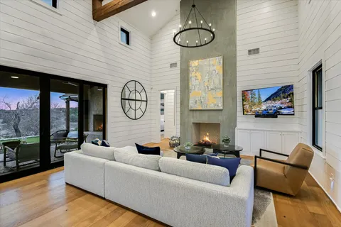 a living room with fireplace furniture and a large window