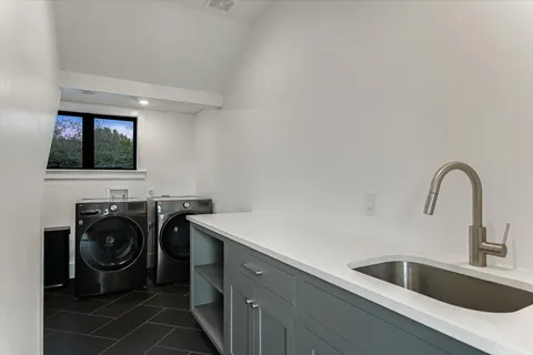 a utility room with sink dryer and washer