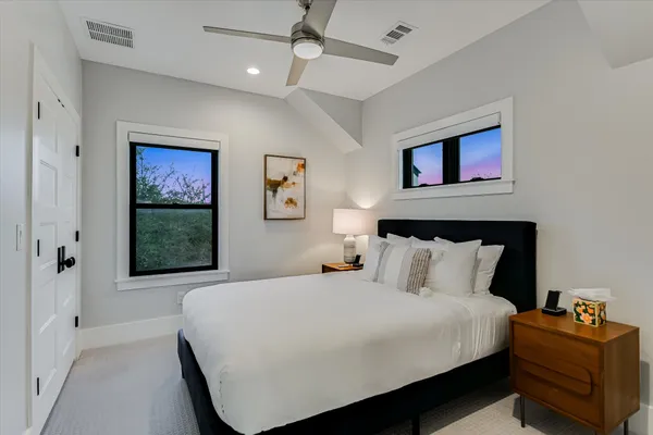 a bedroom with a bed and a painting on the wall