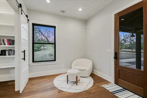 a living room with furniture a window and wooden floor