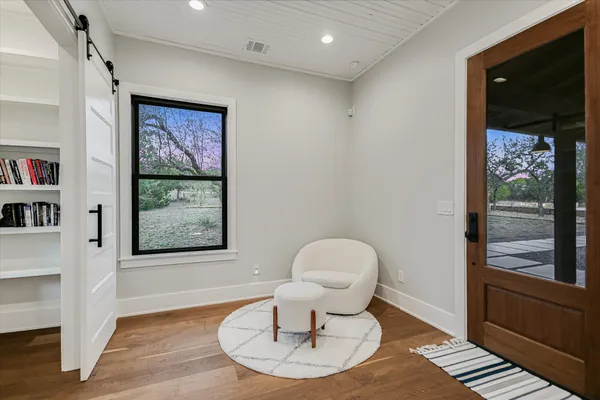 a living room with furniture a window and wooden floor