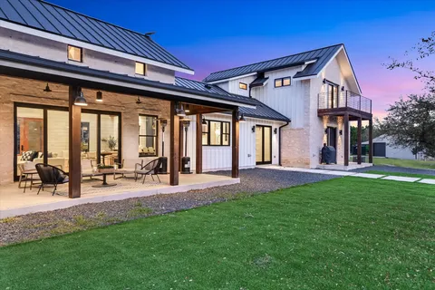 a view of an house with backyard and a tree
