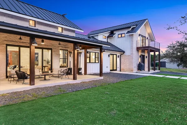 a view of an house with backyard and a tree