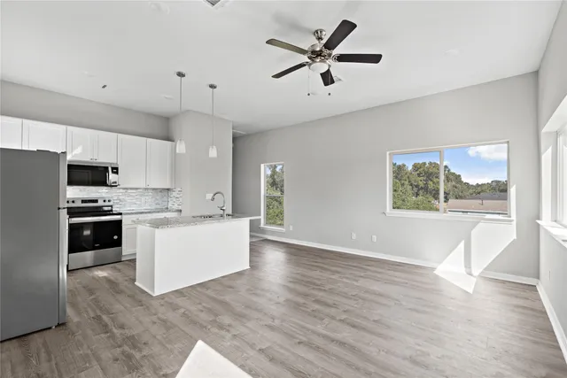 a large kitchen with cabinets wooden floor and stainless steel appliances