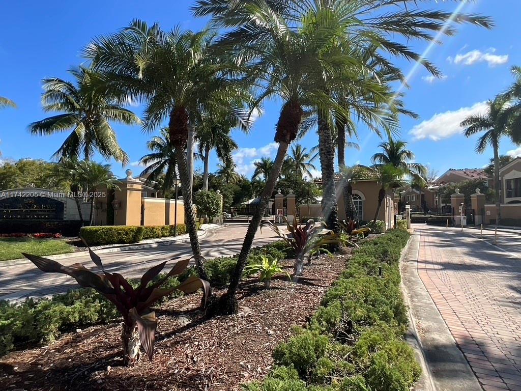 7940 North Nob Hill Road, Unit 201 Tamarac, FL 33321 - Photo 3 of 10 a view of a backyard with a fountain plants and palm trees